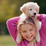 ca. 2003 --- Girl Holding Puppy --- Image by © Stanley Fellerman/Corbis